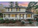 Two-story house with yellow siding, front porch, and landscaping at 9 Post Oak Pl, Salisbury, NC 28147