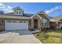 Brick home with a 2-car garage, stone accents, and a manicured lawn at 9515 Liberty Hill Dr, Mint Hill, NC 28227