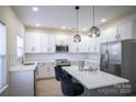 Modern kitchen with white cabinets, quartz countertops, and stainless steel appliances at 105 Fleishhacker Pl, Mooresville, NC 28117