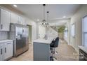 Modern kitchen with island, white cabinets, and stainless steel appliances at 105 Fleishhacker Pl, Mooresville, NC 28117
