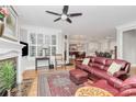 Spacious living room featuring a fireplace, hardwood floors, a ceiling fan, and a luxurious leather sofa and ottoman at 535 Chalmers Row, Rock Hill, SC 29732