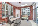 Inviting sunroom with brick walls, skylight, ceiling fan, large windows with shutters, and comfortable wicker furniture at 535 Chalmers Row, Rock Hill, SC 29732