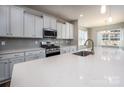 Modern kitchen with white cabinets, quartz countertops, and stainless steel appliances at 242 White Apple Way, Statesville, NC 28625