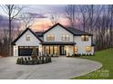 Stunning two-story home with white brick, black trim, circular driveway, and manicured landscaping at 3415 Waxhaw Indian Trail S Rd, Waxhaw, NC 28173