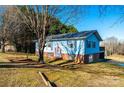 Blue ranch home with a slight hill, landscaping, and trees at 4745 16Th Street Ne Dr, Hickory, NC 28601