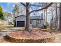 Gray house with a large tree in front and a circular stone border at 1061 Woodlake Ln, Tega Cay, SC 29708