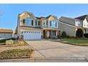 Two-story house with a large front yard, two-car garage, and neutral-colored siding at 112 Artisan Ct, Mooresville, NC 28117