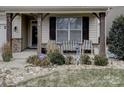 Inviting front porch with seating area, landscaping, and stone accents at 112 Artisan Ct, Mooresville, NC 28117