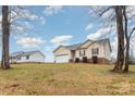 Landscaped yard with a tan house, two-car garage, and driveway at 119 Valerie Dr, Shelby, NC 28152