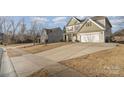 Landscaped yard with a long driveway leading to a two-story house at 217 Stowe Creek Ln, Mount Holly, NC 28120