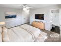 Virtually staged main bedroom with ensuite bathroom and large TV at 801 Crestridge Rd, Statesville, NC 28677