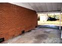 Brick carport with concrete flooring and backyard view at 9737 Feldbank Dr # 7, Charlotte, NC 28216