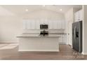 Modern kitchen featuring white cabinetry, granite countertops, and stainless steel appliances at 150 Adams Tree Way, Troutman, NC 28166