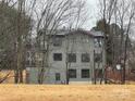 View of multi-story home amongst bare trees, showcasing its architectural design and placement on the property at 150 Driftwood Dr, Mooresville, NC 28117