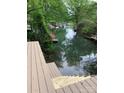 Scenic water view through lush trees from a multi-tiered deck with boat docks across the river at 150 Driftwood Dr, Mooresville, NC 28117