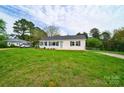 Front view of a charming white house with a green door and a large grassy yard at 2085 Faith Rd, Salisbury, NC 28146