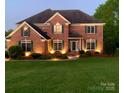 Brick two-story house with landscaped lawn and lighting at 104 Fox Den Cir, Statesville, NC 28677