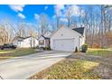 White house with brown accents, a two-car garage, and a grassy yard with fallen leaves at 242 Delview Dr, Cherryville, NC 28021