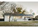 White ranch house with green door, covered porch, and spacious yard at 3069 W Main St, Claremont, NC 28610