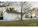 White ranch house with green door, covered porch, and spacious yard at 3069 W Main St, Claremont, NC 28610