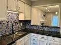 Modern kitchen with blue and white mosaic backsplash and granite countertops at 6130 Heath Ridge Ct, Charlotte, NC 28210