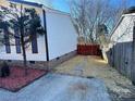 Landscaped side yard with red mulch, a stone path, and a red gate at 7810 Heatherdale Ct, Charlotte, NC 28212