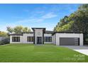 Modern two-story home with a white exterior, black accents, and a three-car garage at 13306 Graymist Dr, Charlotte, NC 28215