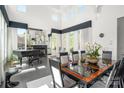 View of the dining room with a large table, piano, and lots of natural light from the big windows at 15618 Frohock Pl, Charlotte, NC 28277
