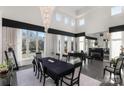 Elegant dining room featuring a grand piano, fireplace, and abundant natural light at 15618 Frohock Pl, Charlotte, NC 28277