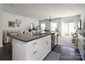 Modern kitchen with white cabinets, granite island, and stainless steel appliances at 318 Willow Wood Ct, Matthews, NC 28104