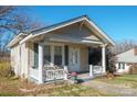 Quaint bungalow features a covered porch and manicured lawn at 625 N 3Rd St, Albemarle, NC 28001