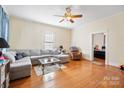 Spacious living room with hardwood floors, a large sectional sofa, and a ceiling fan at 625 N 3Rd St, Albemarle, NC 28001