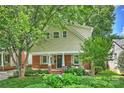 Charming two-story home featuring tan siding, brick accents, inviting front porch, and a beautifully landscaped front yard at 741 Mcalway Rd, Charlotte, NC 28211