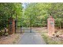 Brick pillars and metal gate open to a tree-lined driveway at 1090 N Saunders Dr, Catawba, NC 28609
