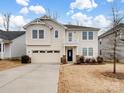 Two-story house with beige siding, a two-car garage, and a well-manicured lawn at 1414 Kings Grove Dr, York, SC 29745