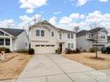 Two-story house with beige siding, a two-car garage, and a well-manicured lawn at 1414 Kings Grove Dr, York, SC 29745