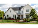 Two-story white farmhouse with landscaping and black fence at 2026 Thatcher Way, Fort Mill, SC 29715