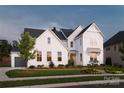 Two-story white farmhouse with gray garage and landscaping at 2026 Thatcher Way, Fort Mill, SC 29715