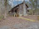 Log cabin home with stone chimney and wrap around porch. Secluded wooded lot at 2577 Dutch Rd, Mount Pleasant, NC 28124