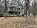 Two-story house with a wraparound porch, surrounded by trees at 701 Victorian Ln, Monroe, NC 28112