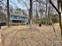 Two-story house with a wraparound porch, nestled in a wooded area at 701 Victorian Ln, Monroe, NC 28112