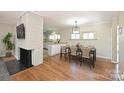 Bright dining room with hardwood floors next to a brick fireplace and open to the kitchen at 738 Brockbank Rd, Charlotte, NC 28209