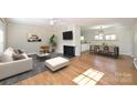 Bright living room featuring hardwood floors, a brick fireplace, and an open concept to the dining area at 738 Brockbank Rd, Charlotte, NC 28209