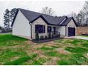 Angle view of home with brick and white siding, black trim, and well manicured yard at 8690 Crestwood Dr, Mount Pleasant, NC 28124