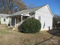 Side view of a one-story house with a covered porch and landscaping at 107 S Inman Ave, Bessemer City, NC 28016