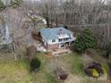 Aerial view of a home with a well-maintained backyard, patio area, and lush surrounding trees at 124 Muirfield Dr, Kings Mountain, NC 28086