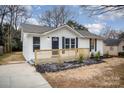 Newly renovated house featuring a white exterior,navy blue shutters, and a small front porch at 433 Greenwood Dr, Charlotte, NC 28217