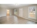 Bright living room with light gray walls, wood-look floors, and access to other rooms at 433 Greenwood Dr, Charlotte, NC 28217