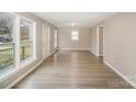 Bright living room with light gray walls, wood-look floors, and access to other rooms at 433 Greenwood Dr, Charlotte, NC 28217