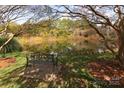 Serene pond with a park bench, surrounded by lush trees and greenery at 6742 Constitution Ln, Charlotte, NC 28210